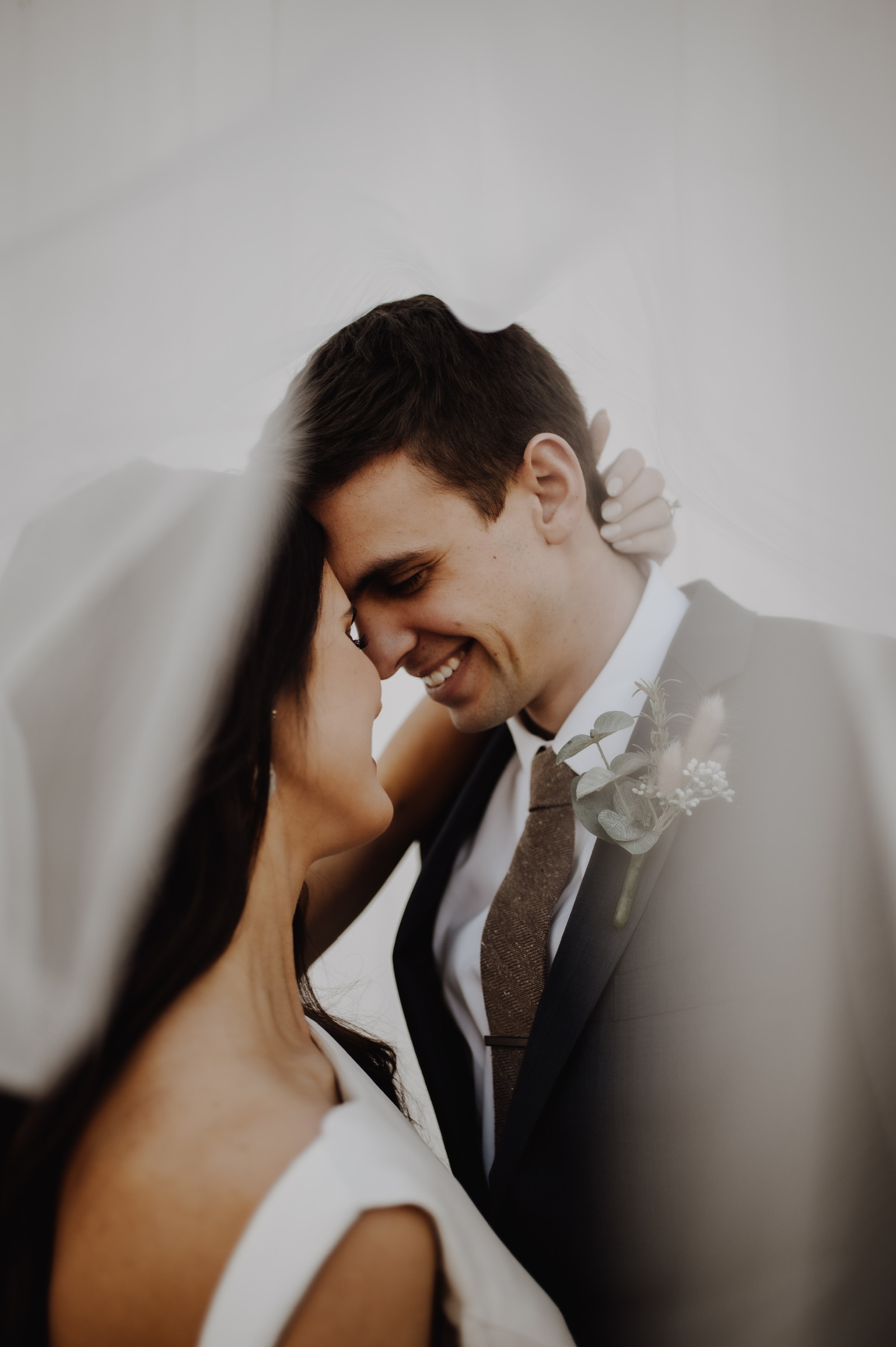 Bride and groom touching foreheads under the veil in the Lehigh Valley, PA